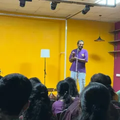 An organizer addresses a full house at Karmasthan. This photo shows our space filled with an attentive audience, highlighting its capacity to host talks, presentations, and community gatherings.