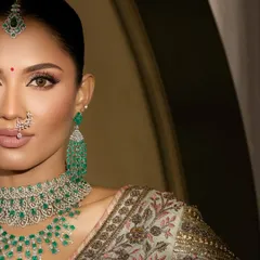 A close-up of this modern bride's look, focusing on the sharp winged liner and flawless skin that allows the stunning emerald jewelry to truly stand out.
