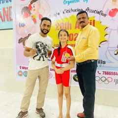 A young champion receives her medal. We prepare our students, including young girls, to compete with confidence and skill in their respective kickboxing categories.