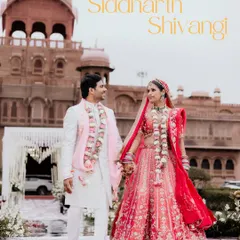 A classic wedding portrait of the couple holding hands in front of the majestic Laxmi Niwas Palace, a perfect blend of love and royalty.