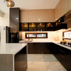 The kitchen in Rakesh and Supriya's villa, where high-gloss finishes and a waterfall island countertop create a space that is perfect for a family that loves to cook and entertain.