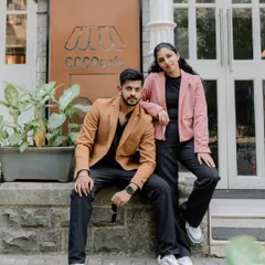 A stylish portrait of a couple posing in front of a chic cafe in Mumbai. Their modern outfits and confident poses are perfect for a contemporary pre-wedding album.