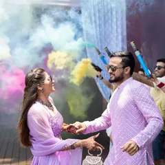 A colorful pool party entry. We choreographed this amazing entrance for the bride and groom, with their friends creating a tunnel of vibrant smoke bombs for them to walk through.