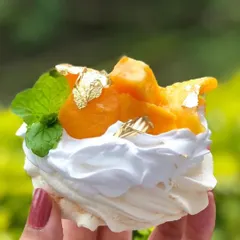 A perfect summer treat. This individual mango pavlova has a crisp meringue shell, fluffy whipped cream, and fresh mango, topped with gold leaf.