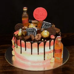 This loaded cake features Jack Daniel's and Johnnie Walker miniatures. The sides have a pink and yellow watercolor effect, contrasted with a rich dark chocolate drip for a truly decadent look.