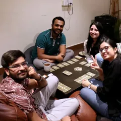 A cozy game night in progress. Friends gather on our comfortable bean bags to play a card game, showing how my space is perfect for relaxed, fun-filled evenings.