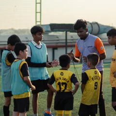 A huddle with one of our expert coaches during a youth training session. Here, he's explaining a tactical concept to the U11 team, breaking down the game so they learn to play smarter, not just harder. This is where young players develop their football intelligence.