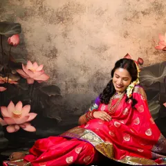 The essence of divine motherhood. The mom-to-be, dressed in a vibrant pink saree, is surrounded by lotus flowers, creating a serene and symbolic portrait reminiscent of Goddess Lakshmi.