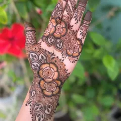 A stunning floral design that covers the back of the hand. The intricate rose patterns are perfect for an engagement or sangeet ceremony.