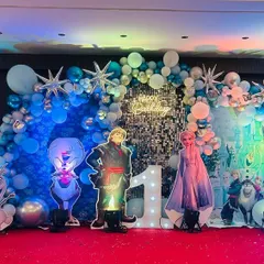 This Disney Frozen theme is perfect for creating a magical winter wonderland. I used a silver shimmer wall, hundreds of blue and white balloons, snowflake accents, and life-sized cutouts of Elsa, Anna, and Kristoff for this special first birthday party.