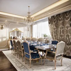 We designed this dining area to be the heart of a timeless, classical residence. The space is defined by its opulence, featuring custom chairs with intricate woodwork, a crystal chandelier, and heavy, patterned drapes that control natural light. The design amplifies the vintage character of the home, creating an elegant setting for formal gatherings.