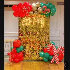 A Christmas-themed take on the popular sequin wall backdrop. I used a gold sequin panel with a 'Let's Party' neon sign, accented with red and green balloons and large candy cane props.
