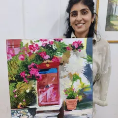 An adult student happily presents her charming painting of a floral doorway, created using acrylics on canvas. Our classes are a perfect way for adults to unwind and engage in a creative hobby.