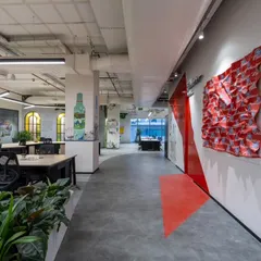 In this hallway at AbInbev, we used bold graphics and a 3D fabric sculpture to create visual interest. The red arrow on the floor is a playful wayfinding element that guides people through the space, while the art on the walls tells the brand's story.