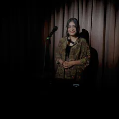 A smile in the spotlight. Performing poetry is a source of immense joy and a way for me to process the world around me.