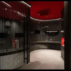 Another perspective of the Fima studio, highlighting how the curved architectural elements are accentuated with light. The design uses darkness as a canvas, with light carefully painted on to guide the eye and feature the displayed products in an artistic, gallery-like setting.