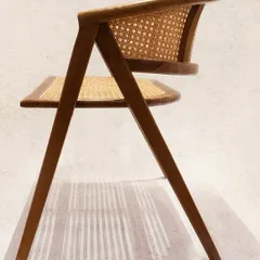 The unique profile of the 'Kyokusen' chair, a testament to innovative design in teak and rattan.