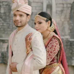 This couple is a vision of elegance. The bride's gold Kanchivaram saree and maroon blouse are perfectly matched with the groom's cream sherwani.