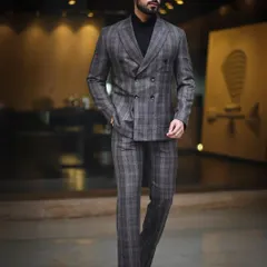 A dynamic walking shot of a model in a plaid suit. This image demonstrates movement and poise, a key shot for any model's portfolio to show how they carry themselves in formal wear.