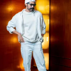 Another look at the layered, all-white outfit. The combination of different fabrics and clean lines showcases the versatility and impact of monochromatic styling.