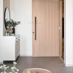 A minimalist and serene entryway. The design includes a simple white shoe cabinet, a round mirror, and a Buddha statue to create a peaceful first impression.