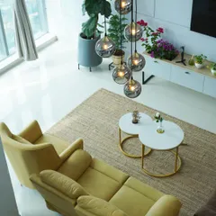 Another angle of the penthouse, showcasing the interplay of light and space. The strategic placement of furniture and the dramatic chandelier draw the eye upwards, emphasizing the room's impressive scale.