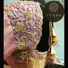 A close-up of a stunning lavender and gold bridal blouse. The entire surface is covered in intricate floral jaal embroidery, showcasing the luxurious texture and craftsmanship that goes into my bridal pieces.