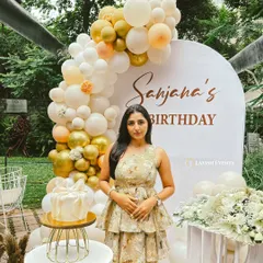 Celebrating a 21st birthday with a sophisticated gold and white balloon arch and natural jute accents.