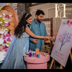 An interactive fingerprint tree activity for a baby shower. The parents-to-be are adding their fingerprints to a "Boy or Girl?" tree, creating a beautiful keepsake while engaging with their guests in a fun way.