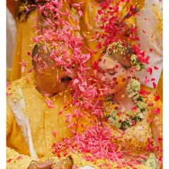 A close-up of the couple being showered with flower petals during their Haldi. These are the colourful, happy memories that make Indian weddings so special.