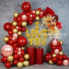 A very grand and stylish 'I LOVE YOU' balloon arrangement. This setup is perfect for proposals or engagements, using a mix of red and gold balloons with pedestals and dried floral accents.