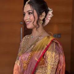 A side profile is crucial for wedding photography. This shot highlights the intricate hair styling with fresh flowers and the seamless blend of the makeup, ensuring the bride looks perfect from every angle.