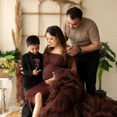 A heartwarming maternity photo with the whole family. The older brother gently touches his mother's belly, beautifully capturing the anticipation of a new sibling.