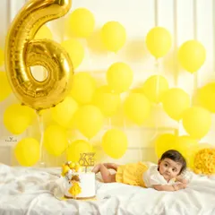 Celebrating the half-birthday milestone. This six-month session features a cheerful yellow theme with a large "6" balloon and a "1/2 Way to One" cake.