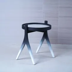We designed this side table to be a piece of functional sculpture, featuring a striking black-to-white gradient on its tripod legs. Its minimalist form and unique finish make it a modern accent piece that adds an artistic touch to a space.