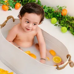 Sunny, bright, and everything nice. A close-up of a baby enjoying a citrus-filled milk bath, a unique and beautiful milestone session.