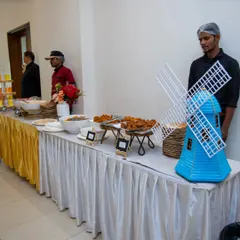 I make celebrations joyful and memorable with thoughtful decor. This buffet table features a charming blue windmill, adding a playful and unique touch to the event's theme.
