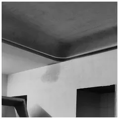 The junction of a curved ceiling and a wall, captured in its raw construction phase. This image highlights the underlying geometry and form that we use to create serene and minimalist interiors.