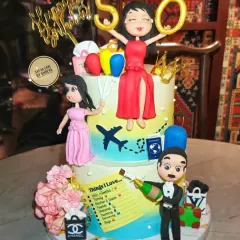 This two-tier cake tells the story of a fabulous 50th birthday. I worked closely with the family to include all her favorite things, from travel and shopping to her beloved family, represented by custom handmade figurines.