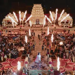 The climax of the ceremony, with pyrotechnics illuminating the temple-inspired mandap and the grand aisle. This bird's-eye view captures the energy and scale of an event where every detail was curated for a magical, immersive experience.