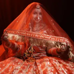 A beautiful shot of a bride holding her dupatta, which has the 'Sada Saubhagyavati Bhava' blessing embroidered on the border.