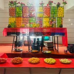 Our grand fruit display table. We create an impressive wall of fresh fruits like apples, oranges, bananas, and pineapples, with cut fruit platters ready for guests to enjoy.