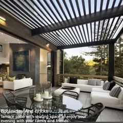 This spacious terrace patio is designed for entertaining. Featuring a large, comfortable seating area and a dining table under a modern slatted pergola, it seamlessly extends the living space outdoors with a view.