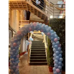 A simple yet effective way to decorate a large entrance or staircase. This long, flowing balloon arch in pastel blue and pink guides guests into the party venue, creating a welcoming and festive atmosphere from the moment they arrive.