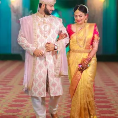 A classic portrait of the bride and groom walking together after their ceremony. Their coordinated outfits and happy expressions tell a story of new beginnings.