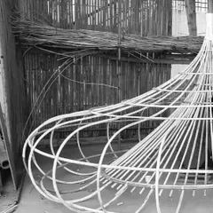 The bare metal skeleton of the oversized light fixture before the weaving process began. This image reveals the structural engineering required to support such a large, handcrafted installation within a commercial space.