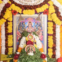 The beautifully decorated shrine for a Satyanarayana Puja, adorned with garlands of fresh flowers.