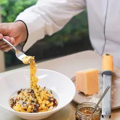 A chef twirls a forkful of our fresh fettuccine. This dish is made with our versatile Aglio e Olio mix, showcasing how our pantry products can create a gourmet meal in minutes.