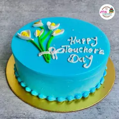 A simple and elegant blue cake with a hand-piped message and a bouquet of flowers, perfect for showing your appreciation on Teacher's Day.