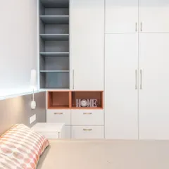 This customized white wardrobe integrates open shelving and closed cabinets for versatile storage. The pop of color in the open niche adds a playful yet stylish element, making it a functional piece of bedroom furniture.